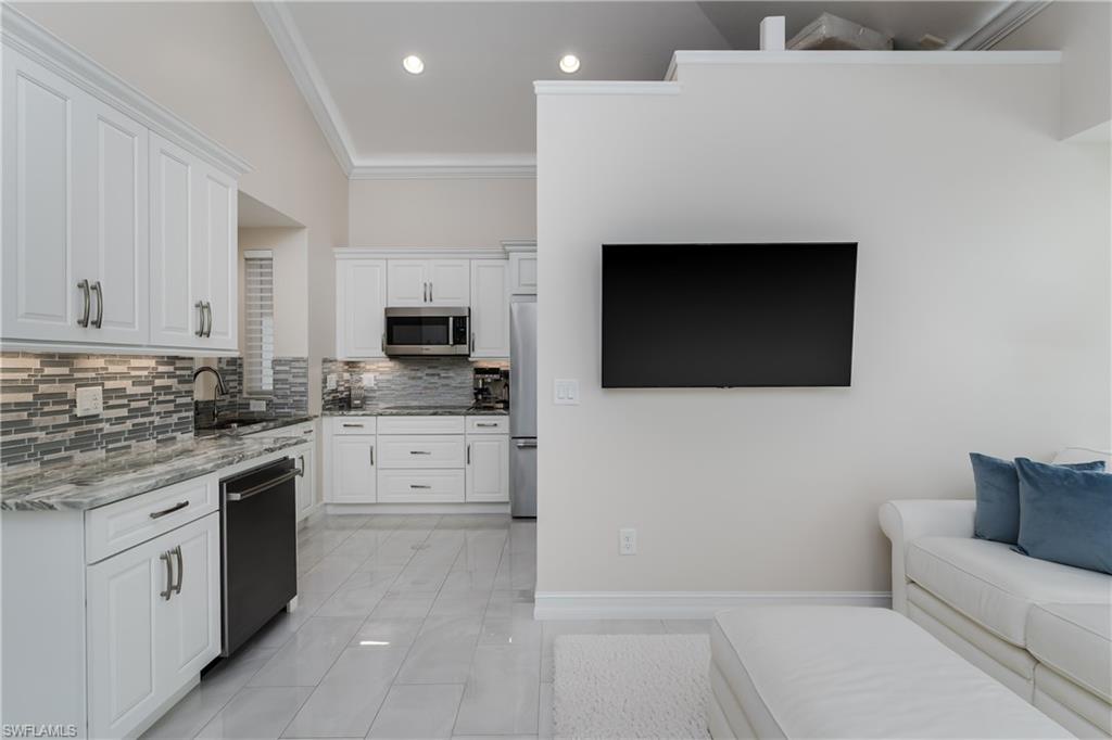 13410 Snook Circle Naples, FL 34114 - Photo 16 of 50 a kitchen with granite countertop white cabinets and stainless steel appliances