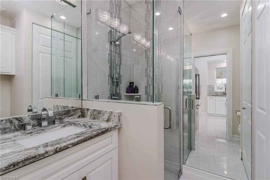 13410 Snook Circle Naples, FL 34114 - Photo 20 of 50 a bathroom with a granite countertop sink mirror and a shower