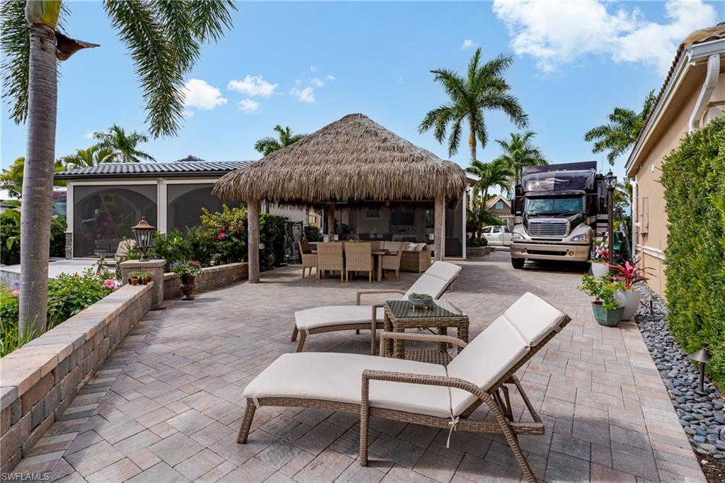 13410 Snook Circle Naples, FL 34114 - Photo 31 of 50 a view of a patio with a table and chairs under an umbrella