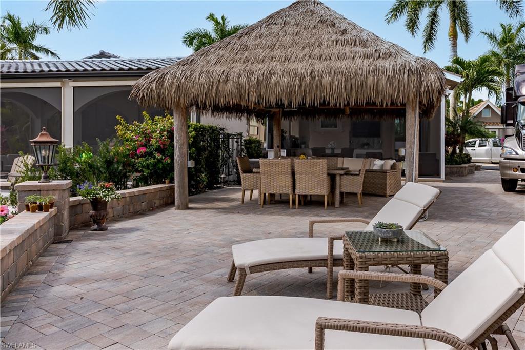 13410 Snook Circle Naples, FL 34114 - Photo 32 of 50 a view of a patio with table and chairs potted plants