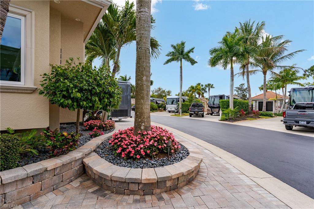 13410 Snook Circle Naples, FL 34114 - Photo 43 of 50 a palm tree sitting in front of a house with a garden