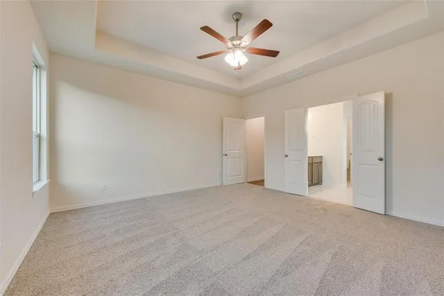 an empty room with a ceiling fan and a window