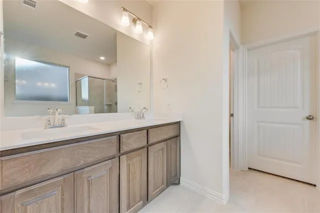 a bathroom with double sink and a mirror