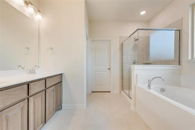 a bathroom with a tub sink and mirror