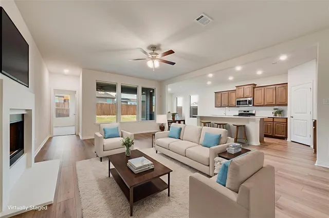a living room with furniture kitchen and a fireplace