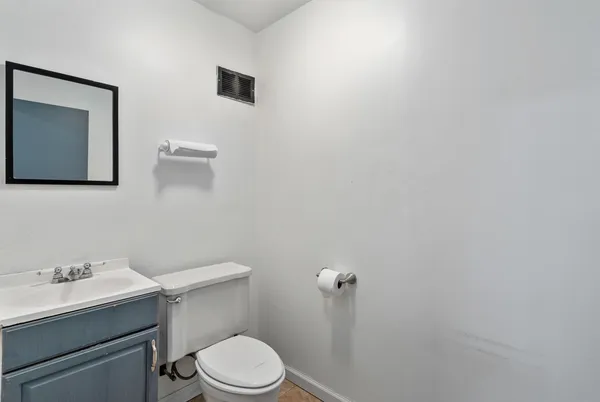 a bathroom with a toilet a sink and mirror