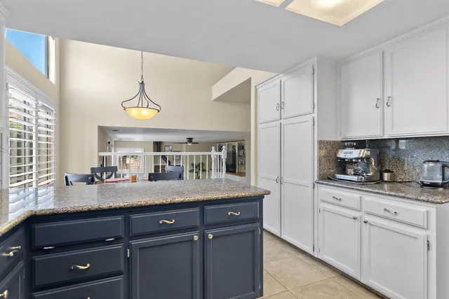 a kitchen with granite countertop a sink cabinets and window