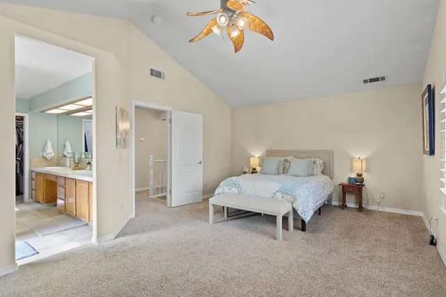a spacious bedroom with a bed and a chandelier
