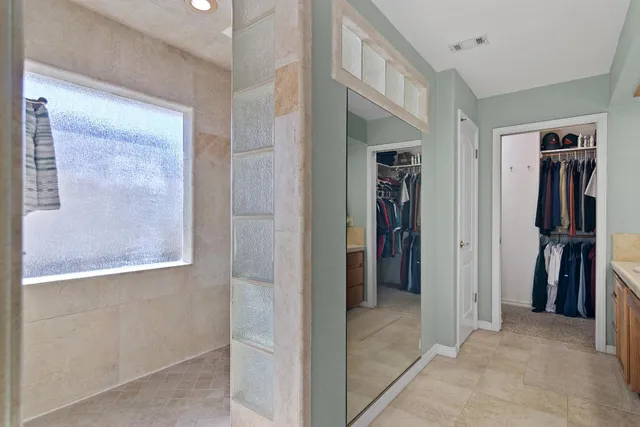 a view of hallway with walk in closet and bathroom