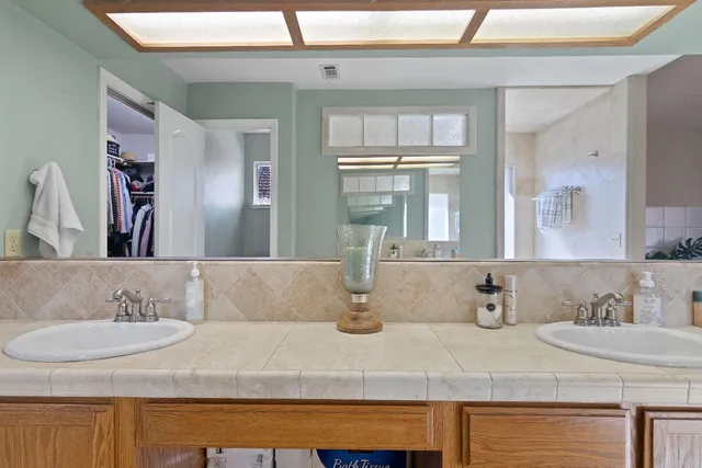 a bathroom with a granite countertop sink and a mirror