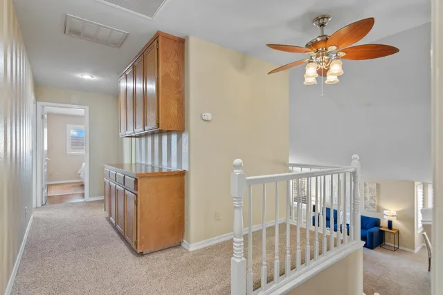 a view of hallway with furniture and chandelier