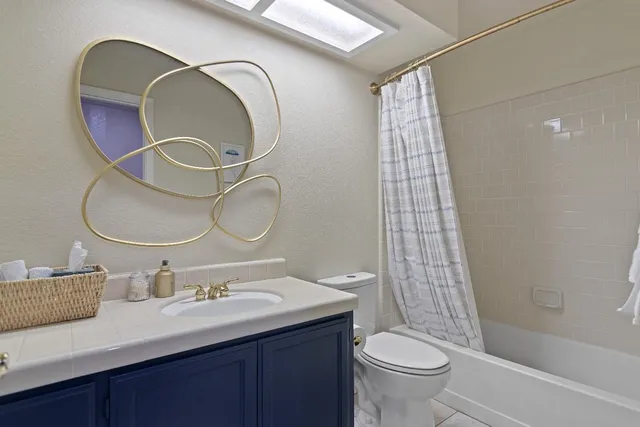 a bathroom with a double vanity sink toilet and shower