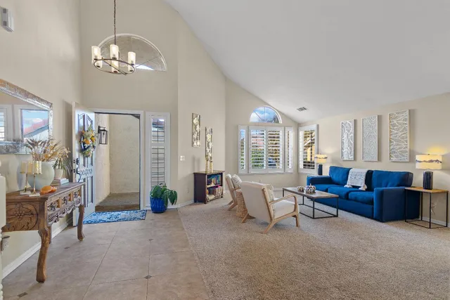 a living room with furniture and a chandelier