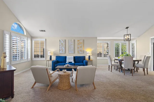 a living room with furniture a flat screen tv and windows