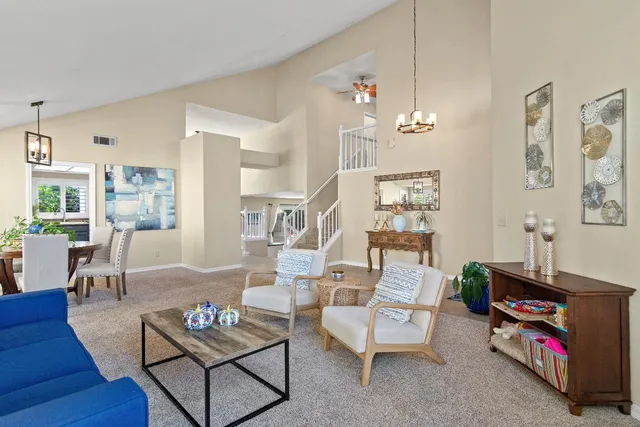 a living room with furniture a rug and a chandelier