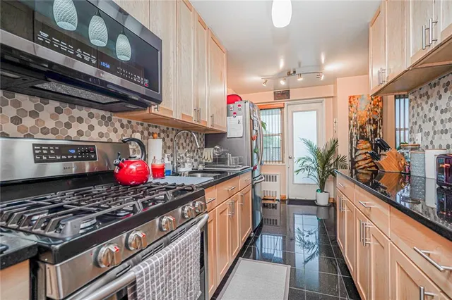 a kitchen with stainless steel appliances granite countertop a stove a sink and a refrigerator