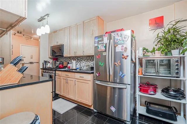 a kitchen with stainless steel appliances a refrigerator sink and cabinets
