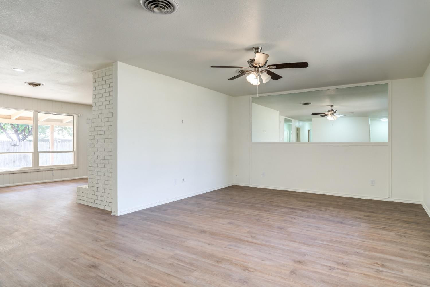 2119 67th Street Lubbock, TX 79412 - Photo 11 of 42 wooden floor in an empty room with a window