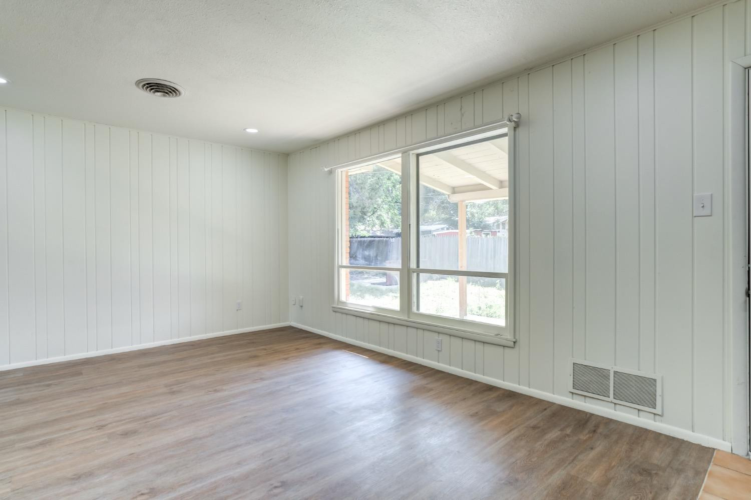 2119 67th Street Lubbock, TX 79412 - Photo 18 of 42 an empty room with wooden floor and windows