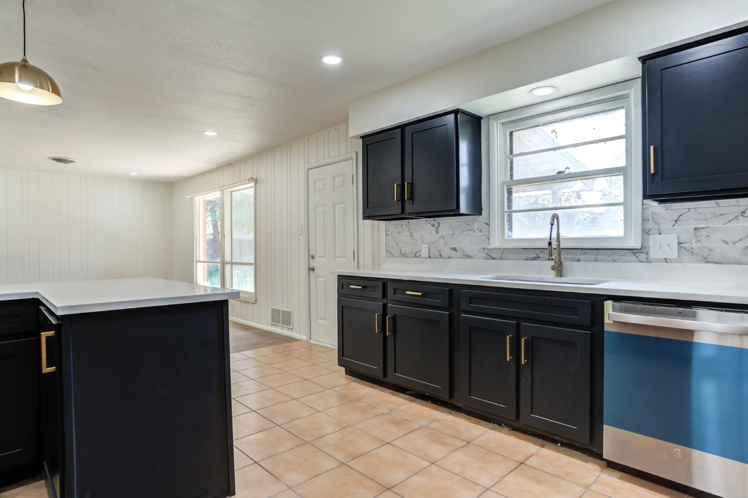2119 67th Street Lubbock, TX 79412 - Photo 23 of 42 a kitchen with a sink dishwasher a stove and a refrigerator