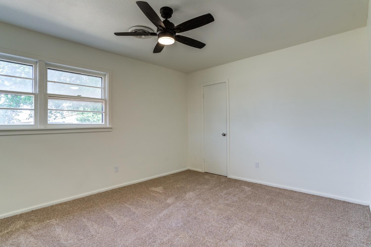 2119 67th Street Lubbock, TX 79412 - Photo 26 of 42 an empty room with a window and a fan