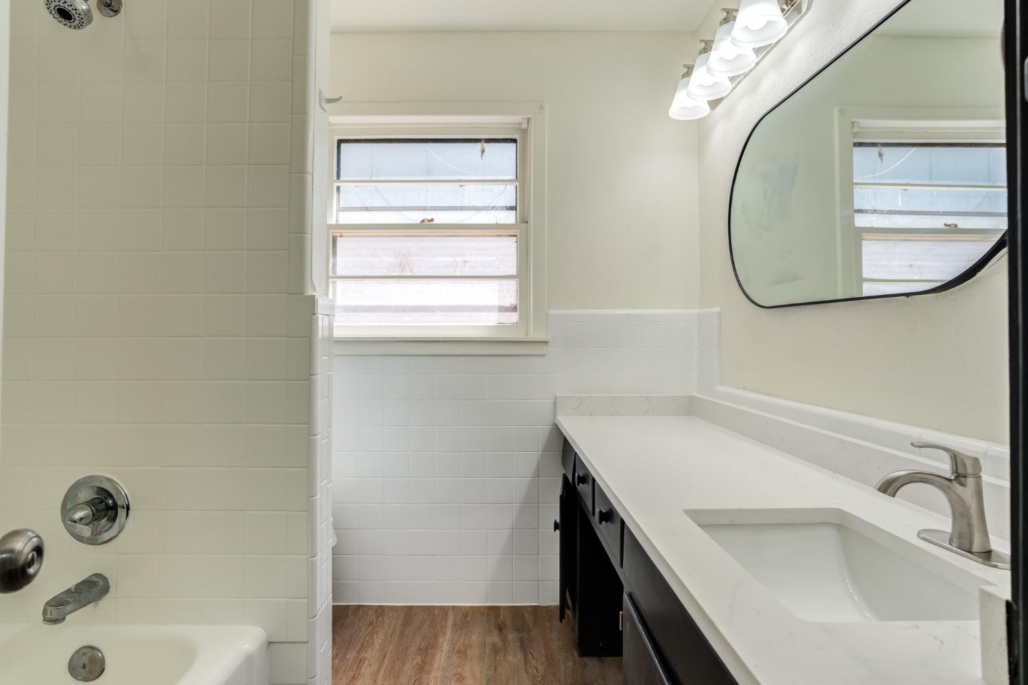 2119 67th Street Lubbock, TX 79412 - Photo 30 of 42 a bathroom with a sink and a mirror