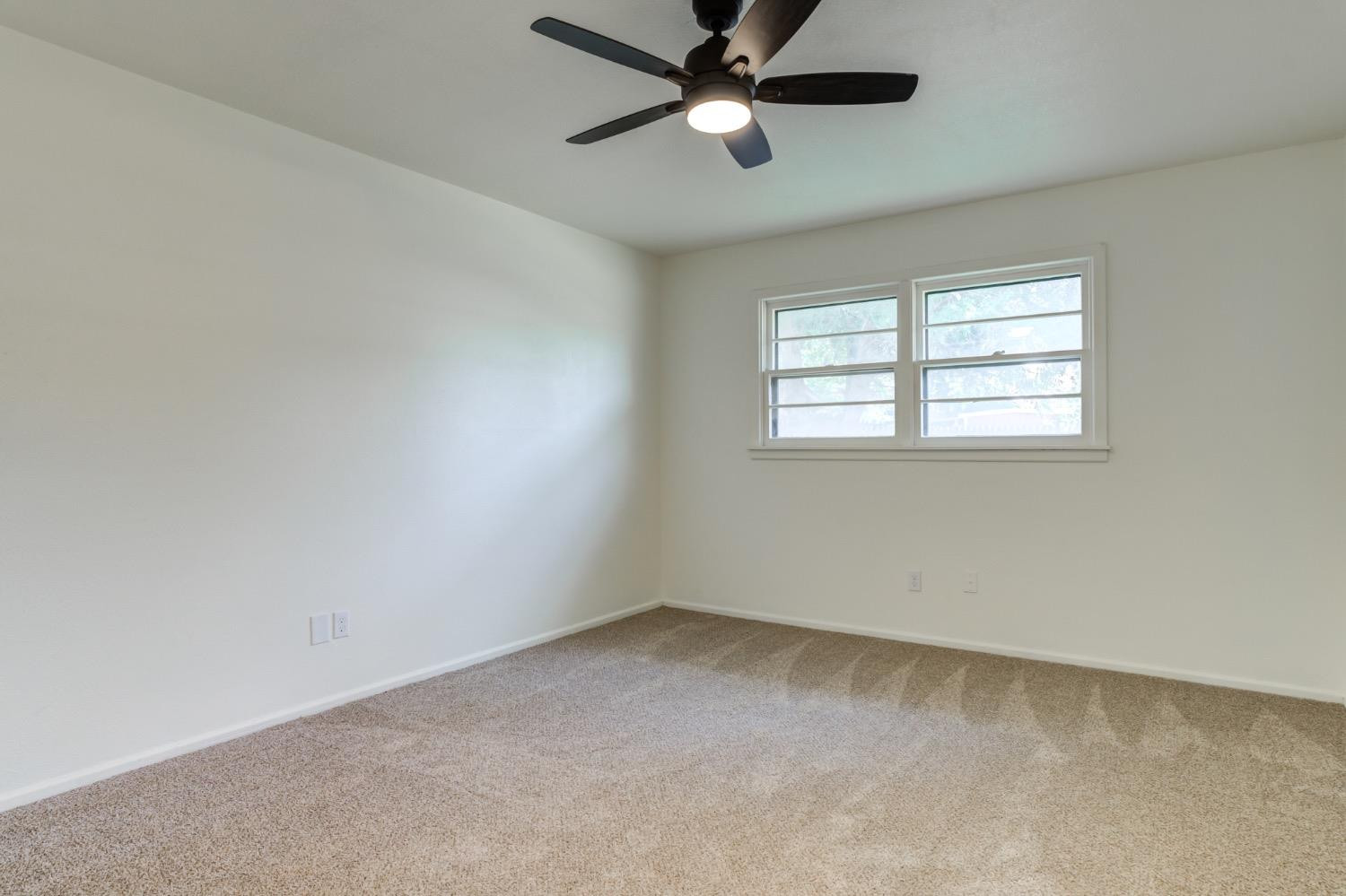 2119 67th Street Lubbock, TX 79412 - Photo 32 of 42 an empty room with a window and a fan