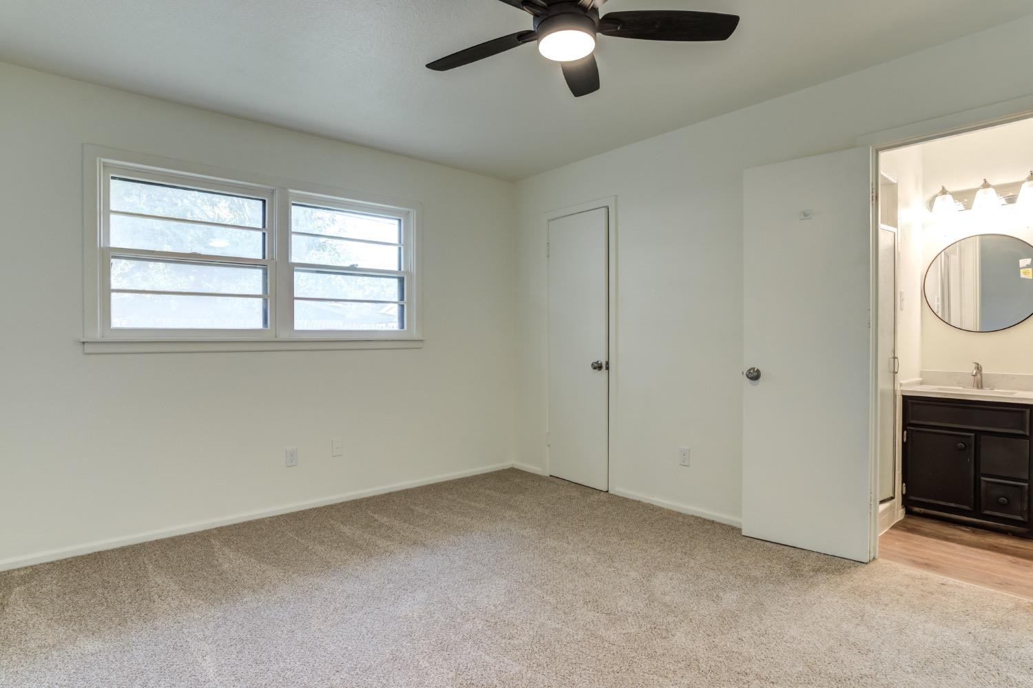 2119 67th Street Lubbock, TX 79412 - Photo 33 of 42 an empty room with chandelier fan and windows