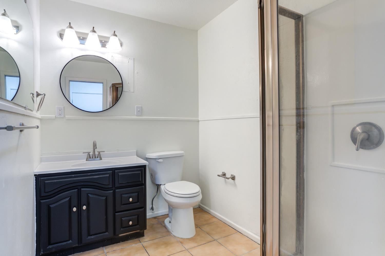 2119 67th Street Lubbock, TX 79412 - Photo 38 of 42 a bathroom with a toilet a sink and a mirror