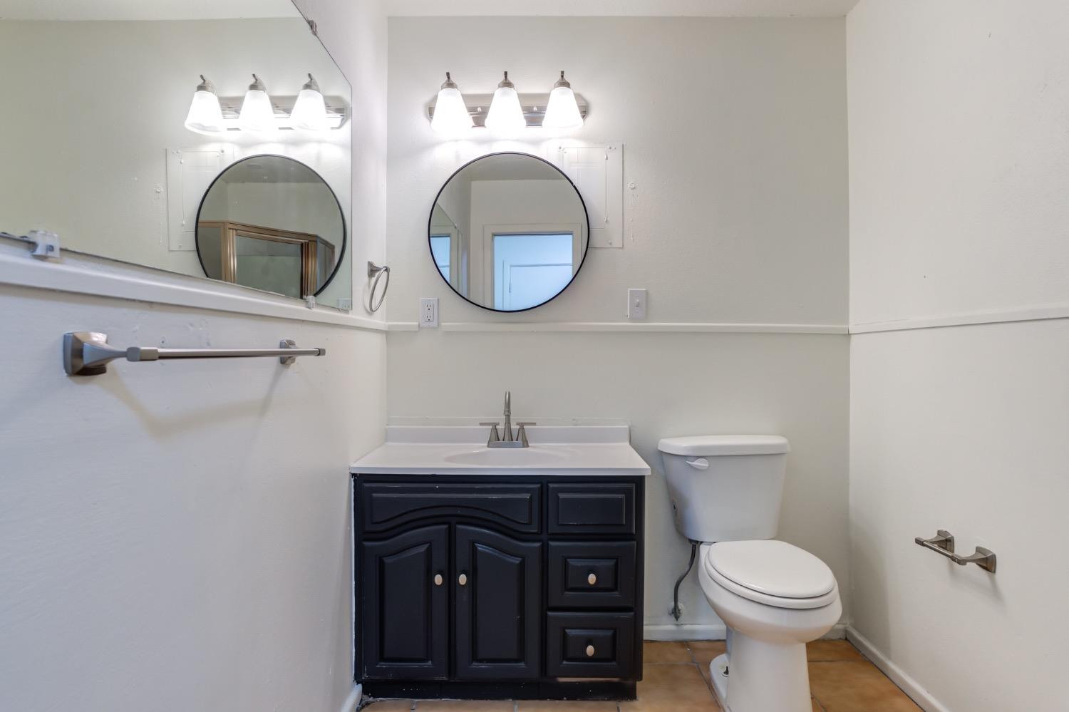 2119 67th Street Lubbock, TX 79412 - Photo 39 of 42 a bathroom with a toilet sink vanity and mirror