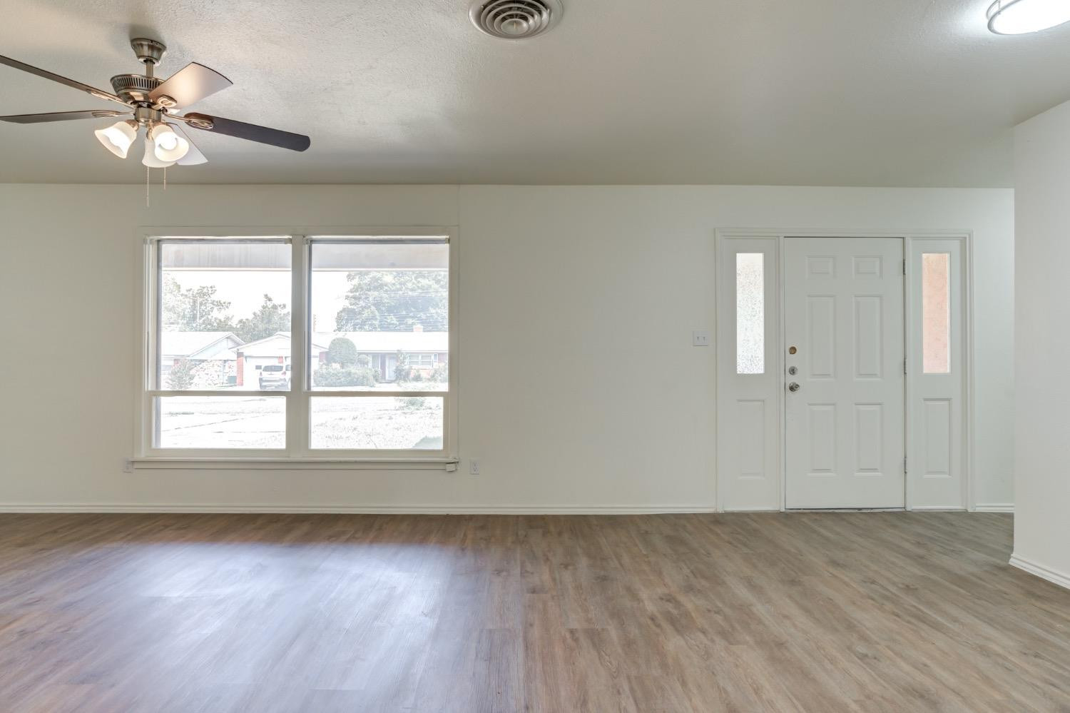 2119 67th Street Lubbock, TX 79412 - Photo 5 of 42 a view of an empty room with a window and a fan