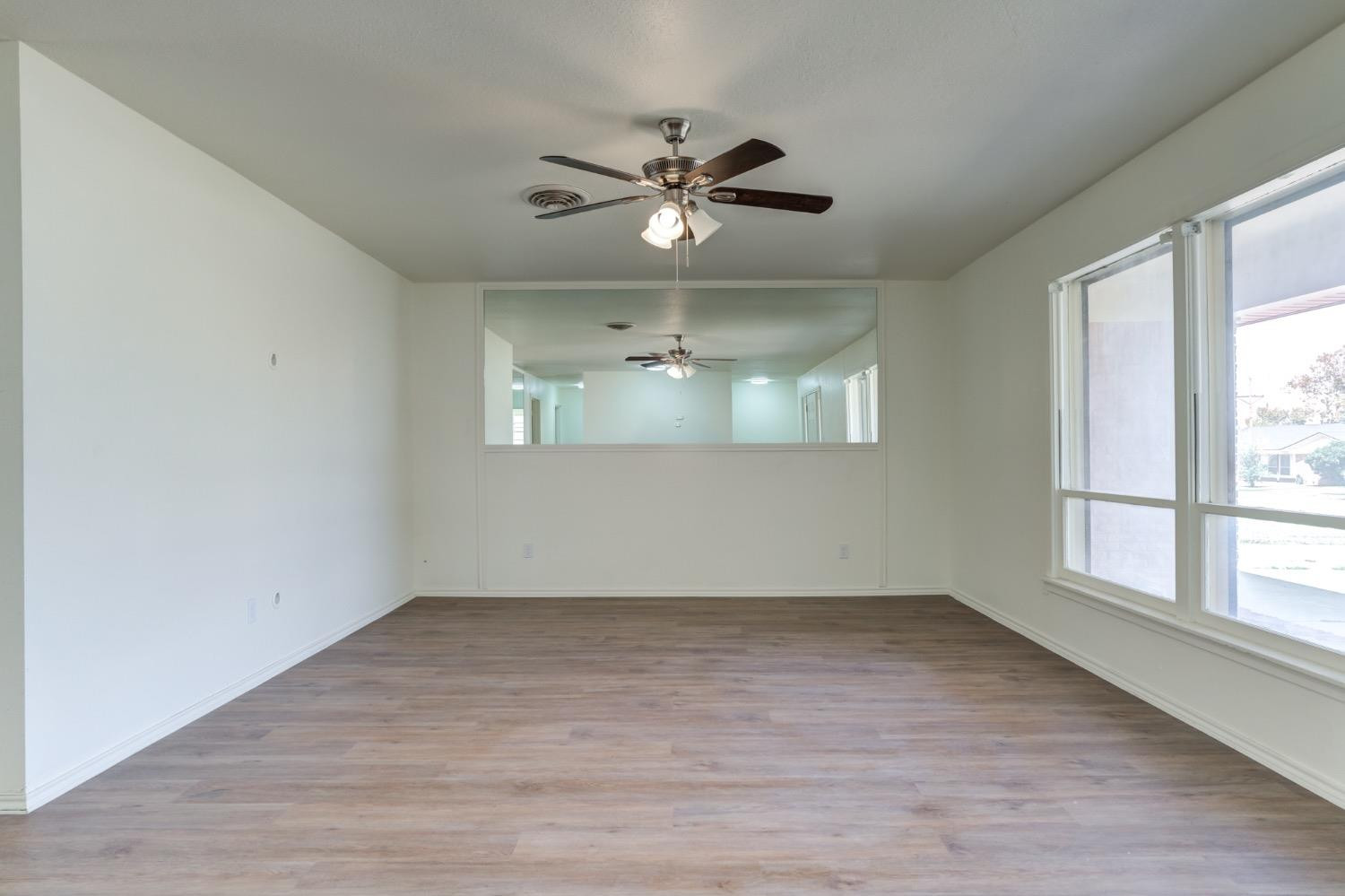 2119 67th Street Lubbock, TX 79412 - Photo 6 of 42 wooden floor in an empty room with a window