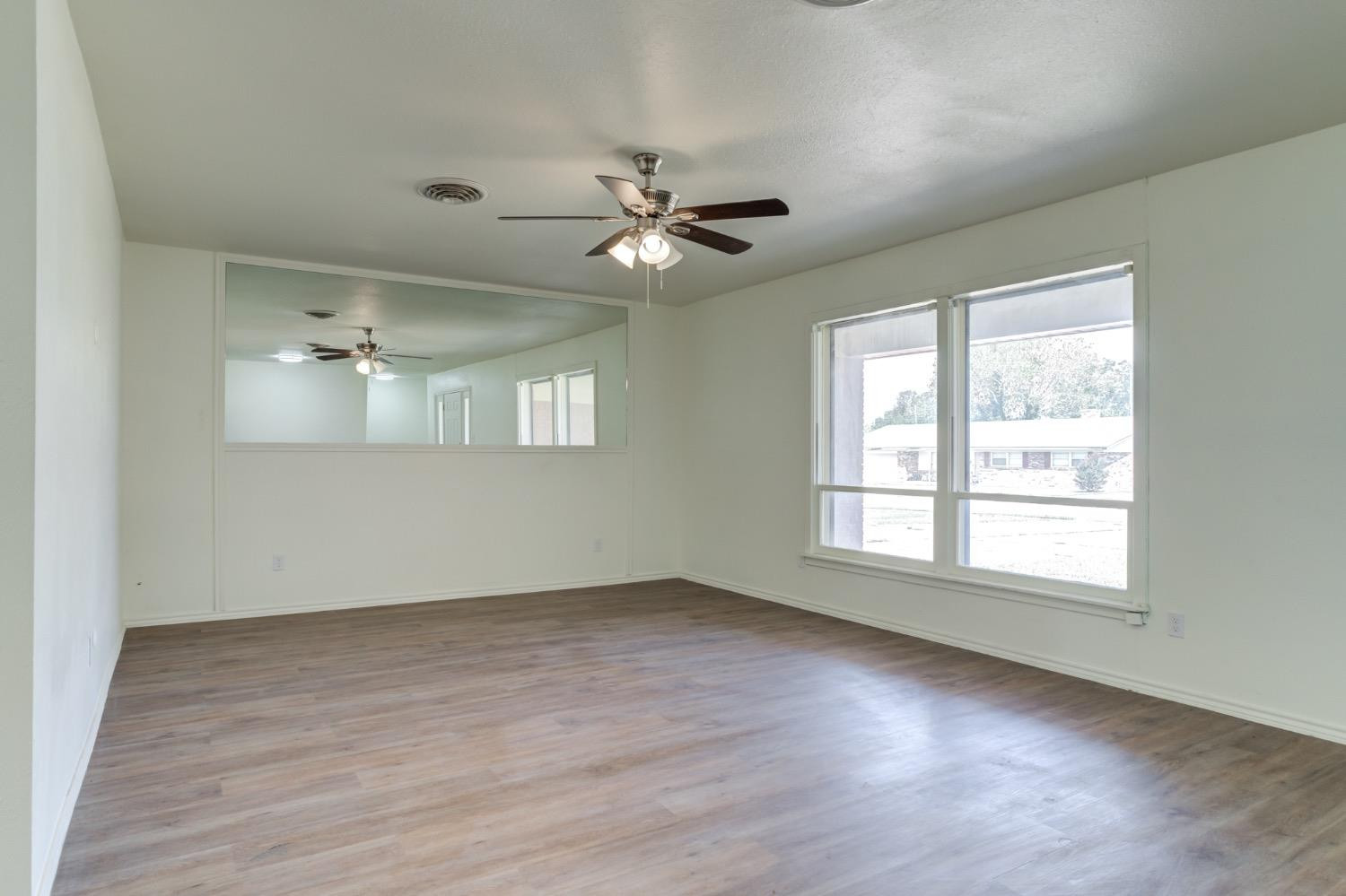 2119 67th Street Lubbock, TX 79412 - Photo 7 of 42 wooden floor in an empty room with a window