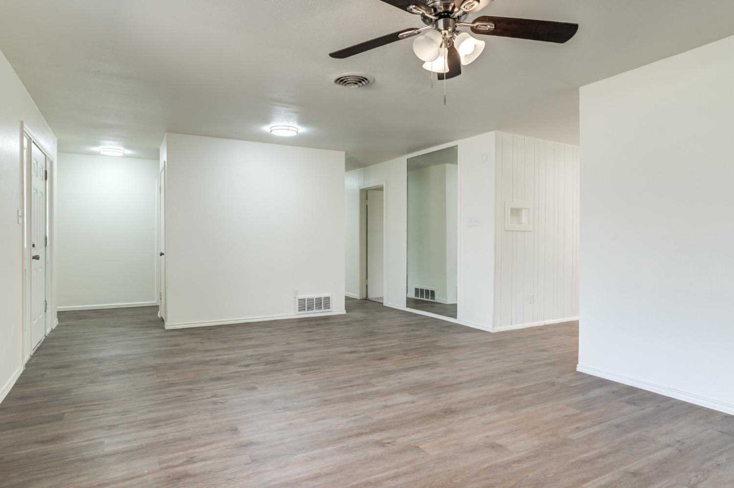 2119 67th Street Lubbock, TX 79412 - Photo 10 of 42 an empty room with wooden floor fan and windows