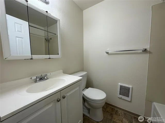 a bathroom with a sink mirror vanity and toilet