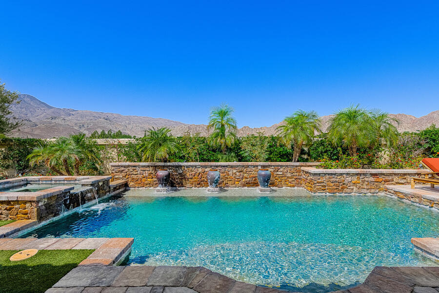 a view of a swimming pool with an outdoor seating yard and mountain view in back