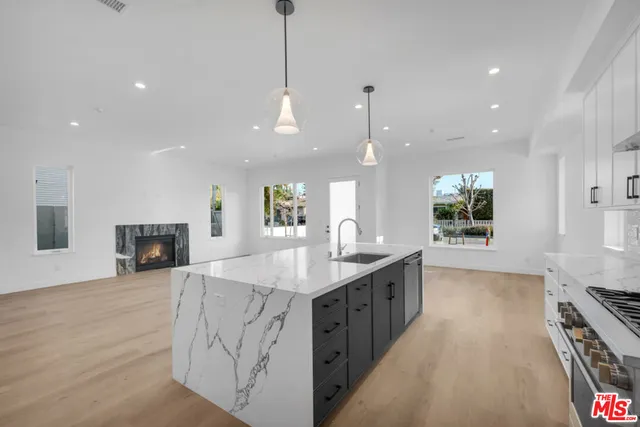 a kitchen with stainless steel appliances granite countertop a sink a oven and a wooden floor