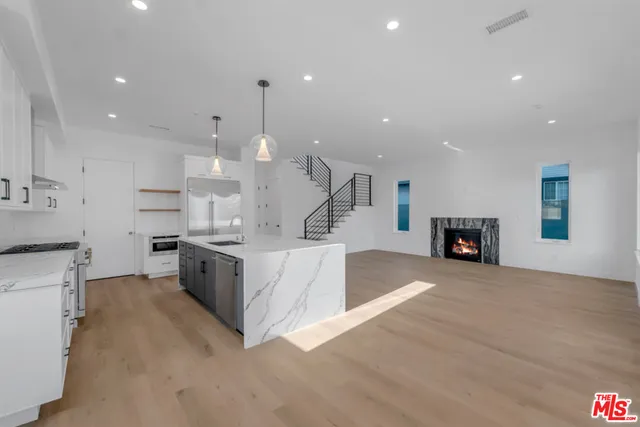 a large kitchen with stainless steel appliances kitchen island a large counter top and a stove top oven