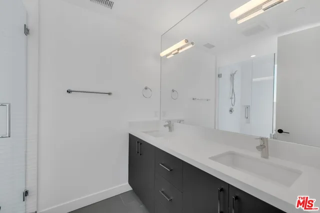 a bathroom with a sink double vanity and a mirror