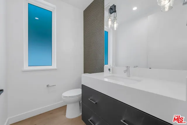 a bathroom with a sink a toilet and a mirror