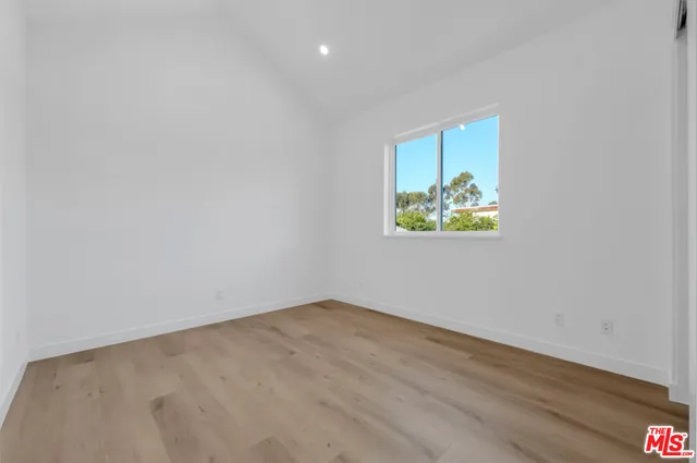 an empty room with wooden floor and window