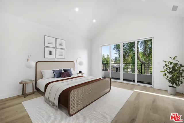 a bed sitting in a spacious bedroom next to a large window