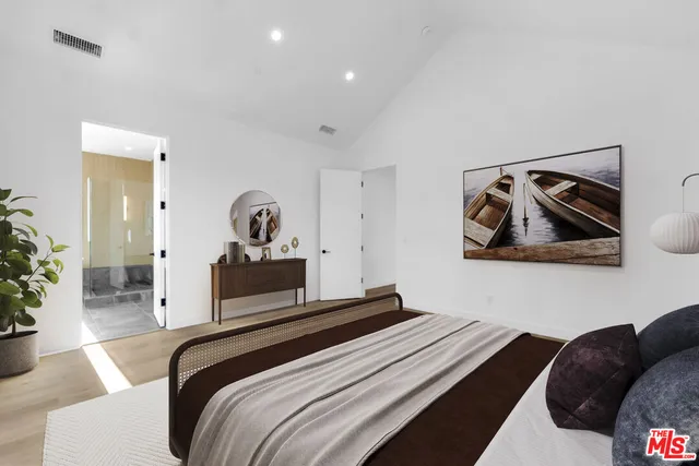 a bedroom with a bed and painting on the wall