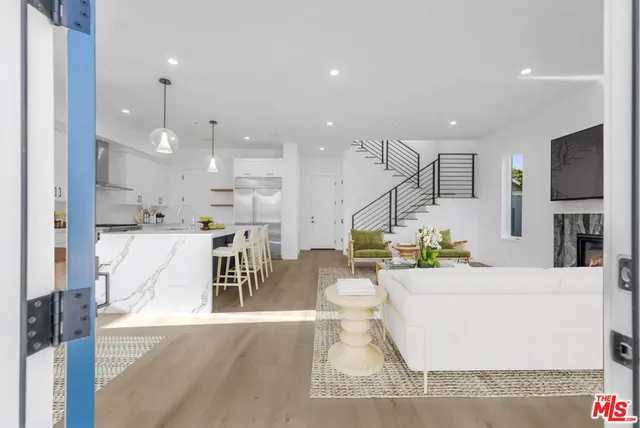 a living room with kitchen island furniture and a chandelier