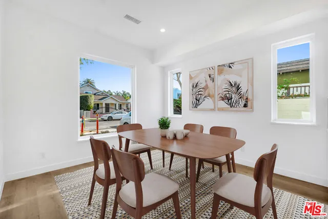 a view of a dining room with furniture a rug and wooden floor
