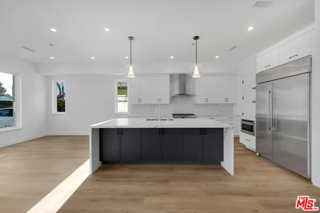 a view of kitchen with refrigerator stove and a sink