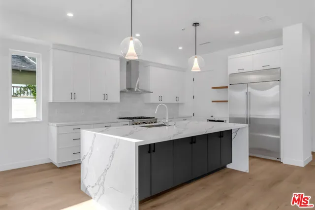 a kitchen with kitchen island a sink stainless steel appliances and cabinets