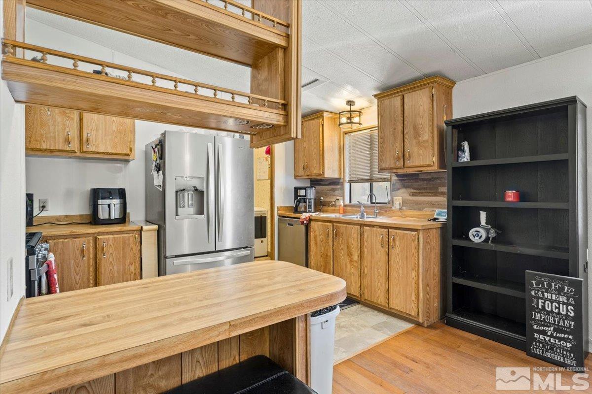 3867 Puffin Street Reno, NV 89508 - Photo 12 of 29 a kitchen with stainless steel appliances kitchen island granite countertop a refrigerator a stove and white cabinets with wooden floor