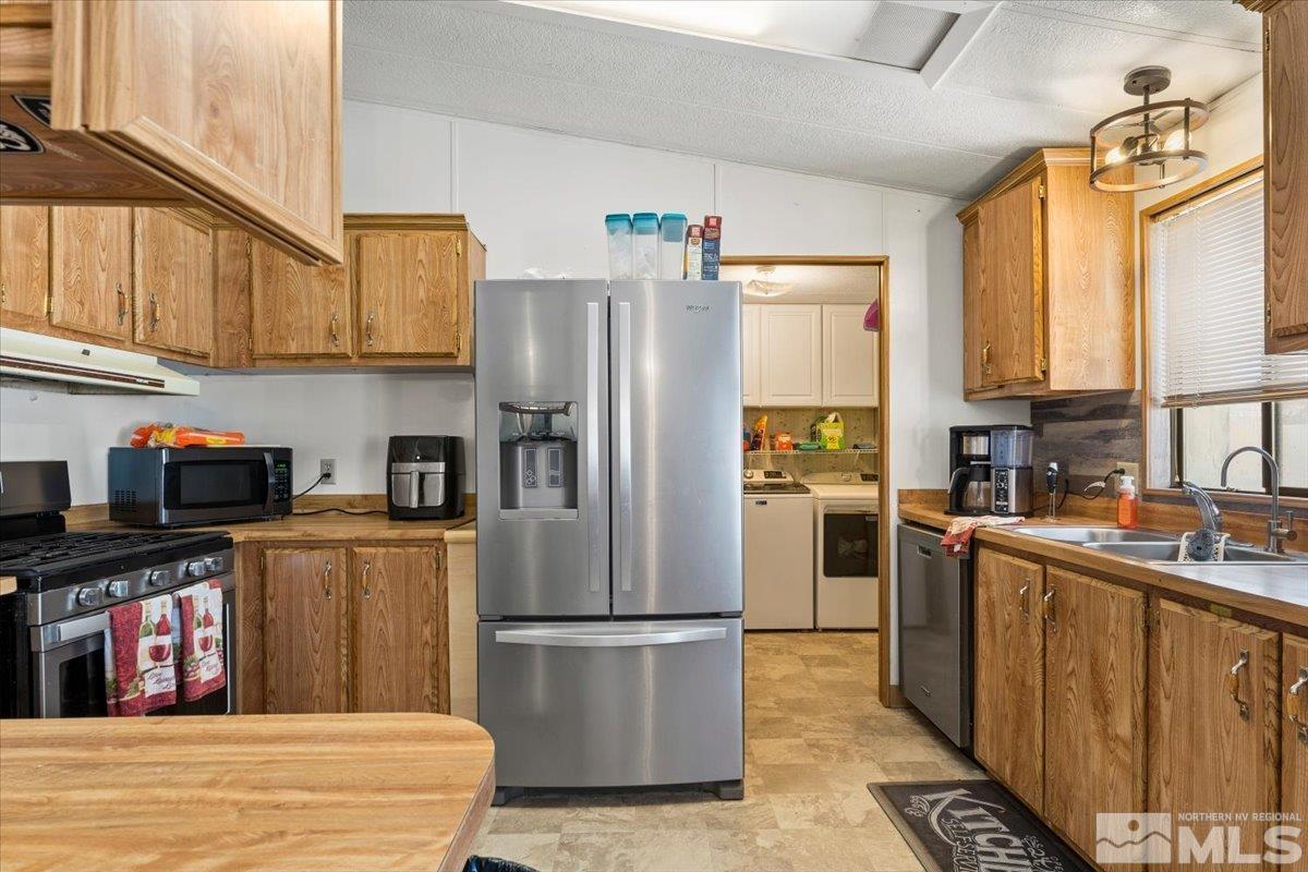 3867 Puffin Street Reno, NV 89508 - Photo 13 of 29 a kitchen with stainless steel appliances granite countertop a refrigerator sink and stove