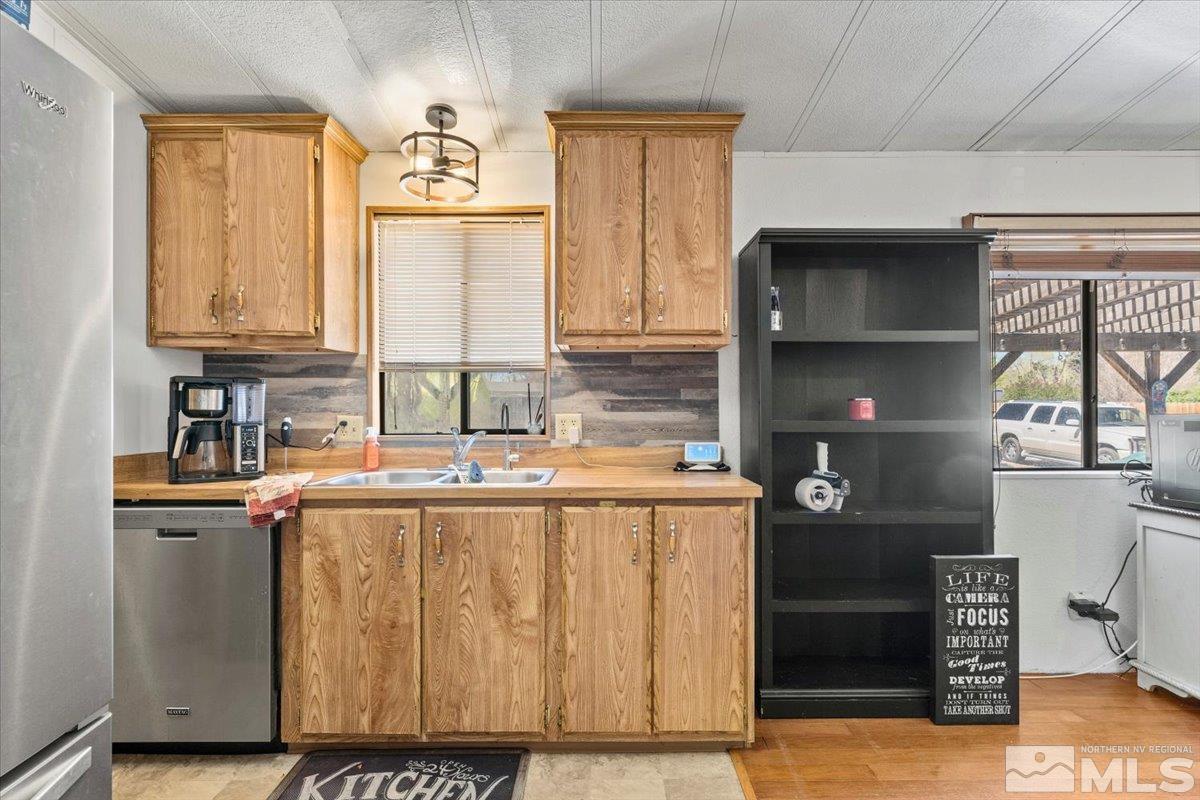 3867 Puffin Street Reno, NV 89508 - Photo 16 of 29 a kitchen with stainless steel appliances granite countertop a sink and a refrigerator